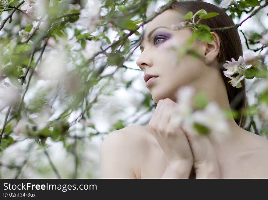 Young girl near blooming apple tree