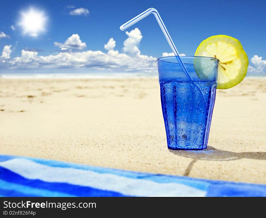 Glass of sparkling water on a beach