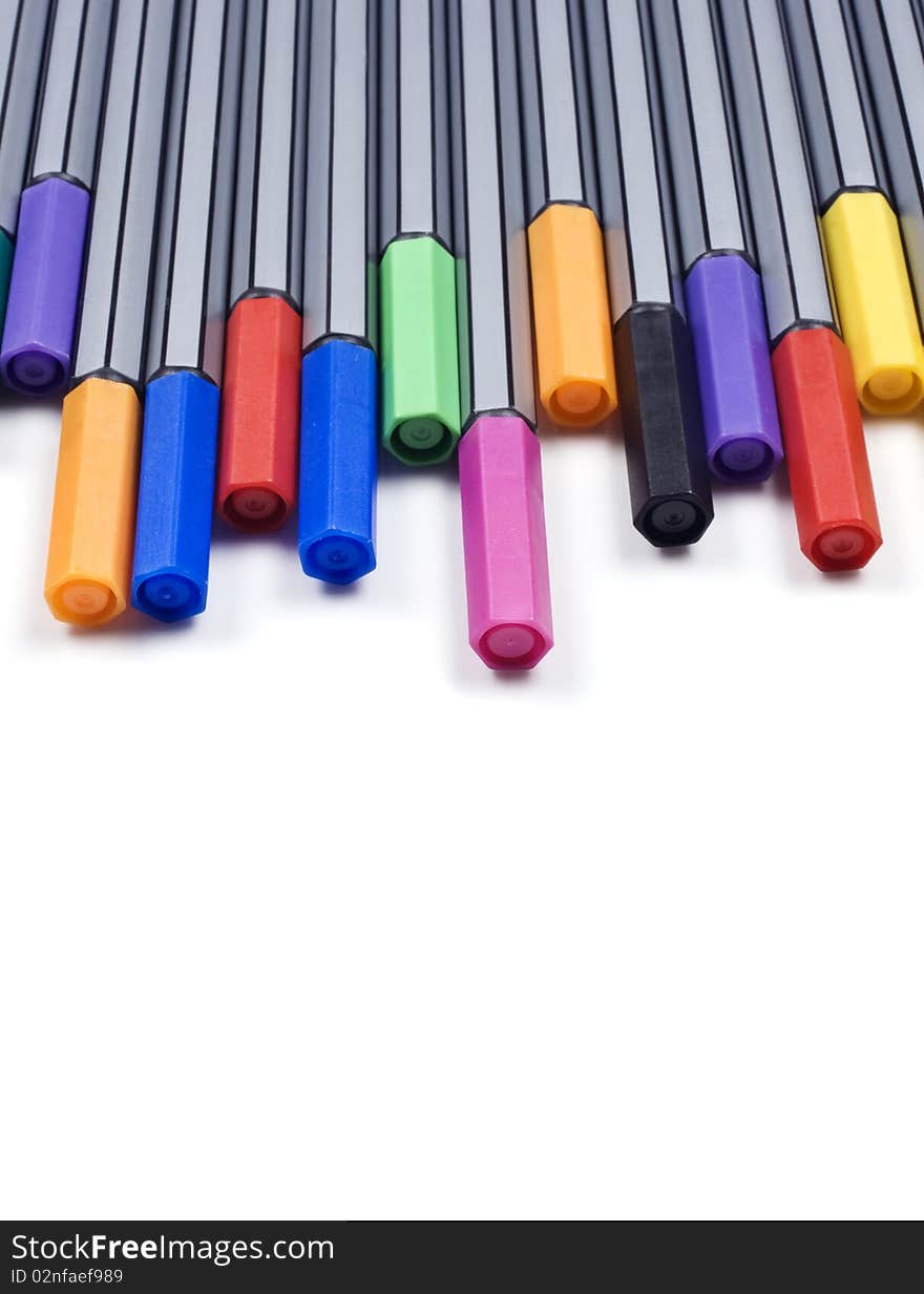 Colourful pens on a white background with space for text