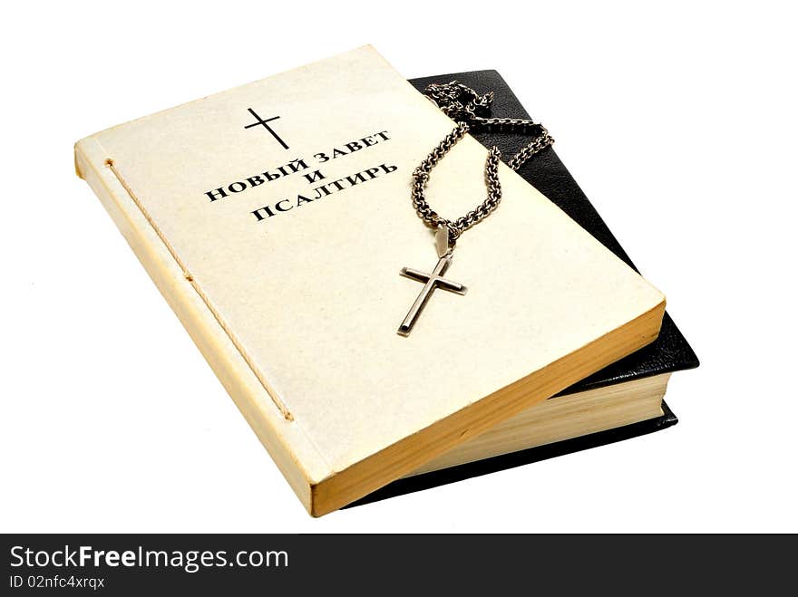 Book of the Bible and a silver cross and chain on white background