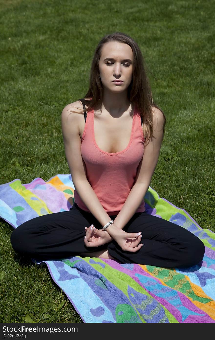 A woman trying to relax her mind while sitting down and meditating and relaxing with her eyes closed. A woman trying to relax her mind while sitting down and meditating and relaxing with her eyes closed.