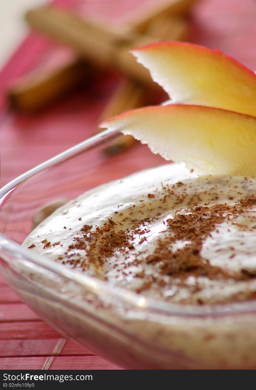 Pudding with apple and nut in ice glass and red background