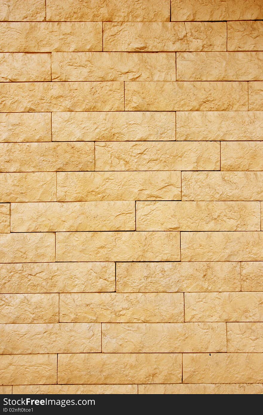 A grunge wall texture. The facade view of beige brick wall. Could be used as design background. A grunge wall texture. The facade view of beige brick wall. Could be used as design background