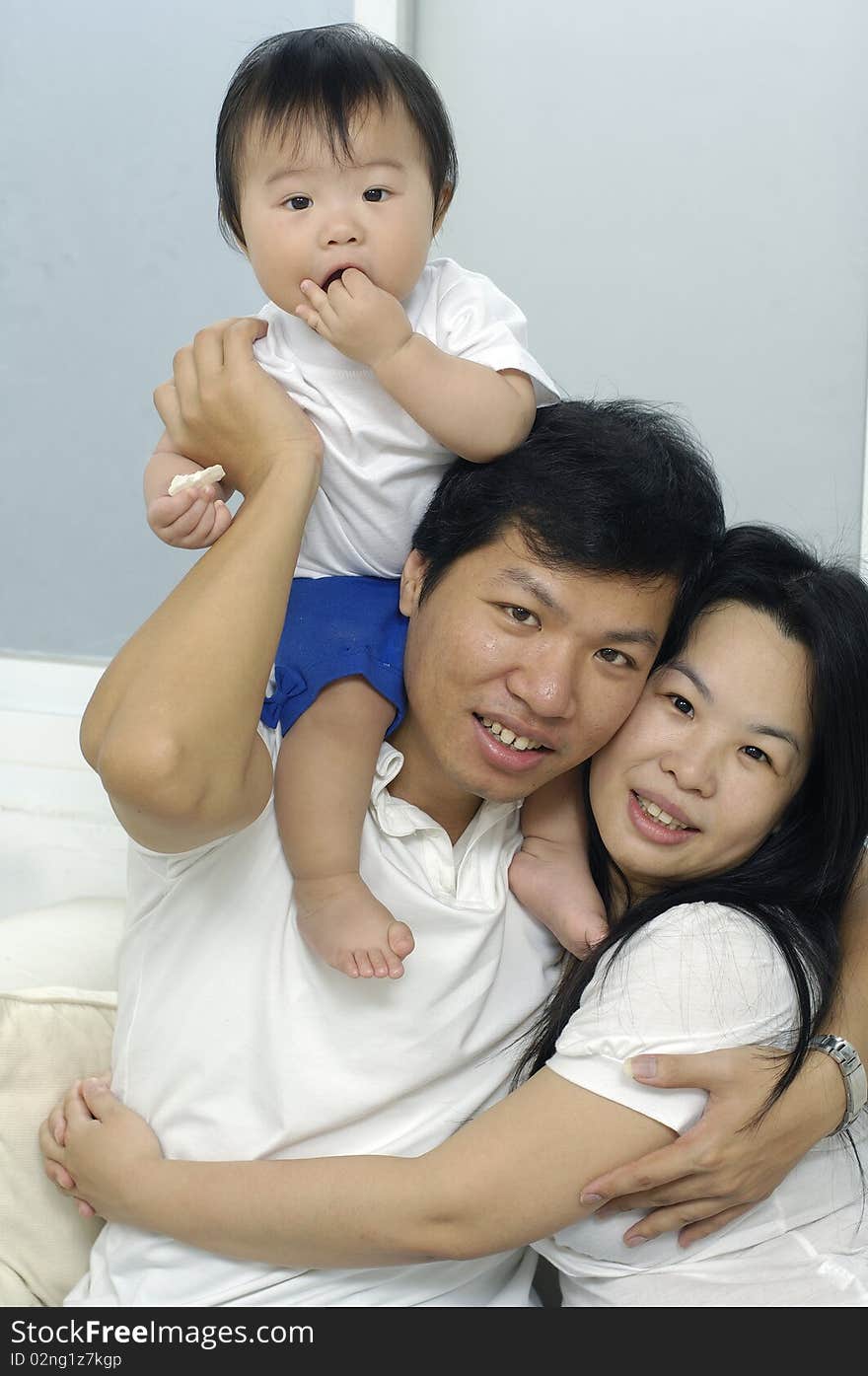 Asian family smiling together in living room