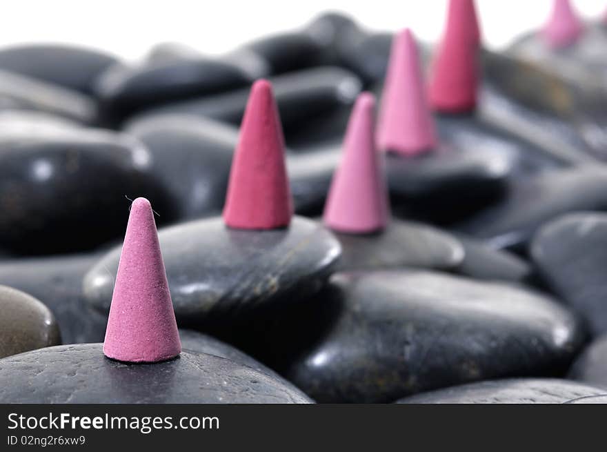 A row of incense cones on pebbles