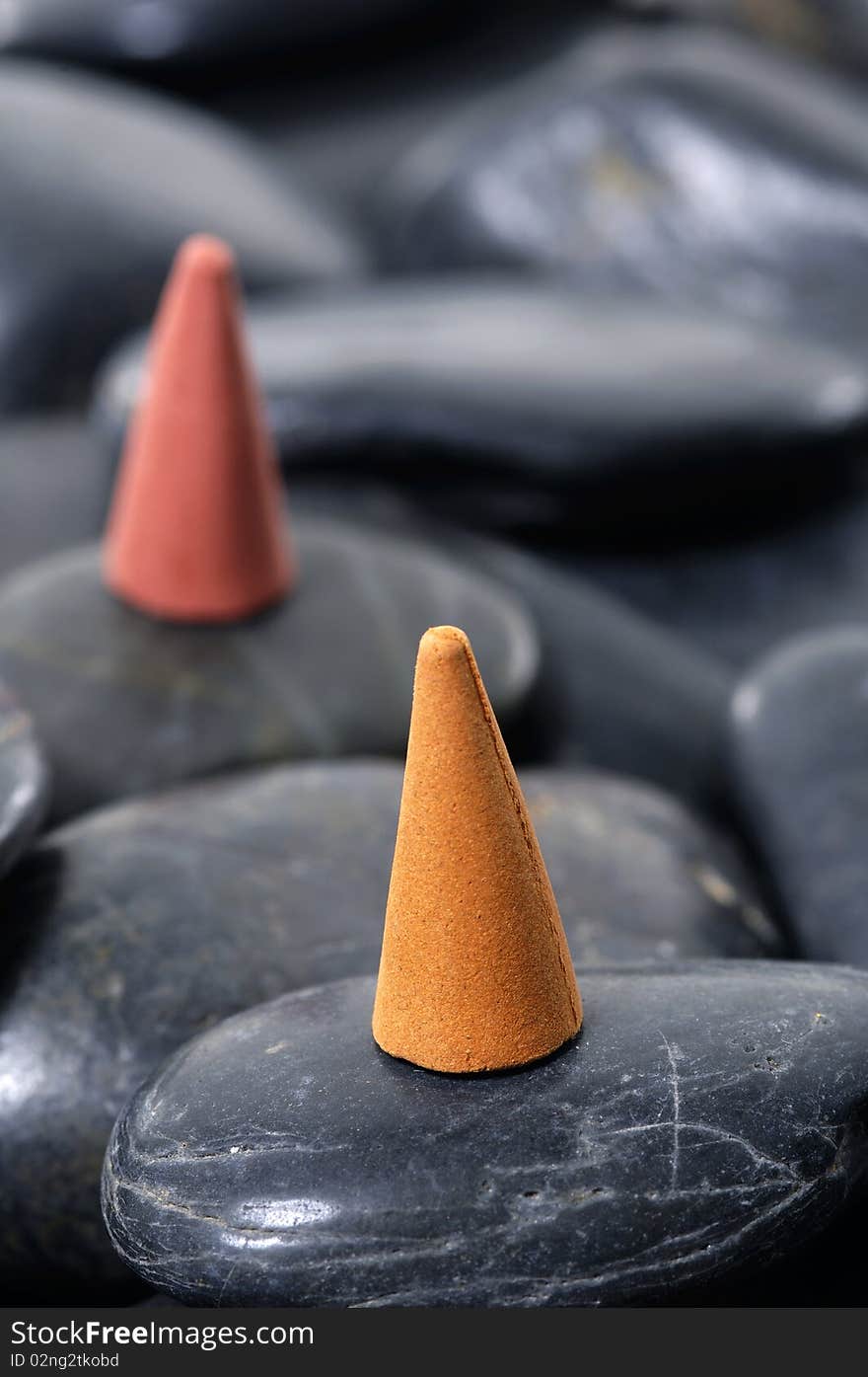 A row of incense cones on pebbles