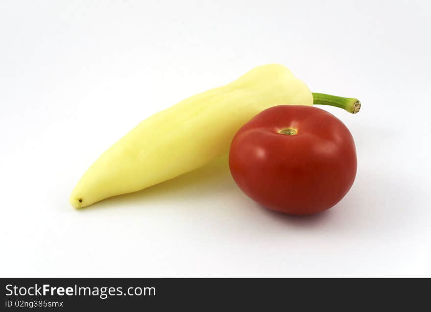 Yellow pepper and tomato on white