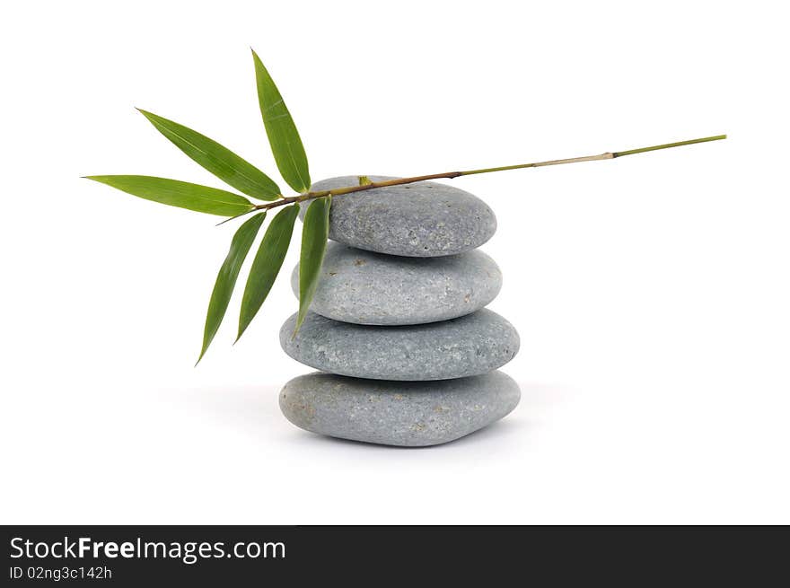 Balanced stones with bamboo leaf on white. Balanced stones with bamboo leaf on white