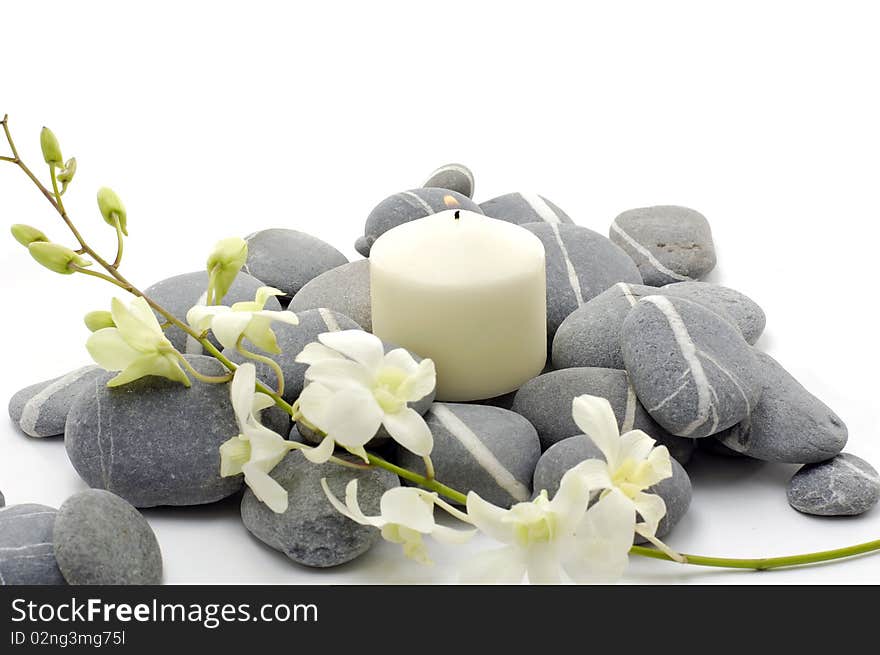 Spa setting with beautiful white flowers, pebbles and candle. Spa setting with beautiful white flowers, pebbles and candle.