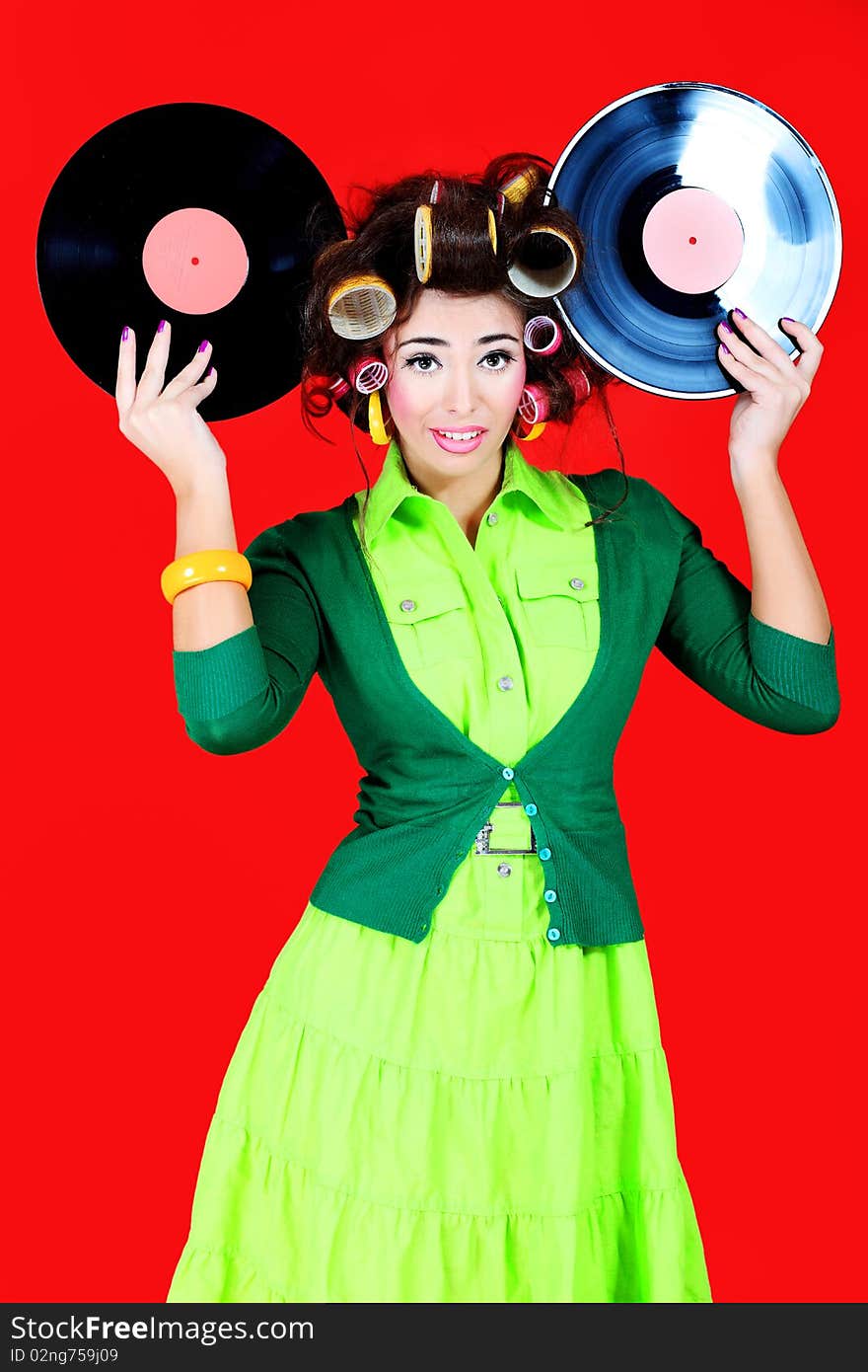 Portrait of a woman with curlers on her hair holding gramophone record. Retro style. Portrait of a woman with curlers on her hair holding gramophone record. Retro style.