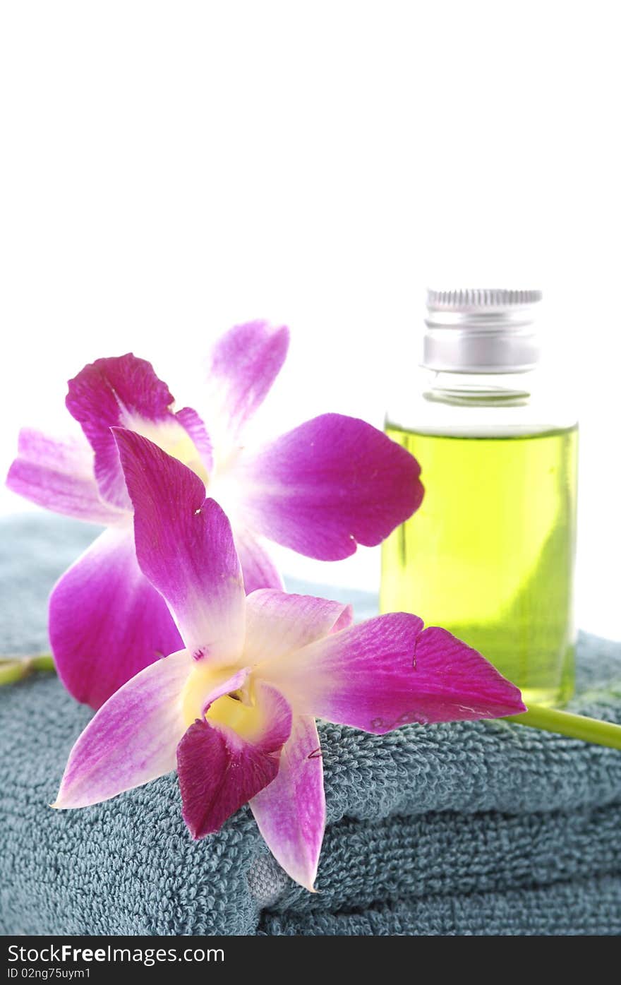 bottles of essential oil with .orchid on blue towel. bottles of essential oil with .orchid on blue towel