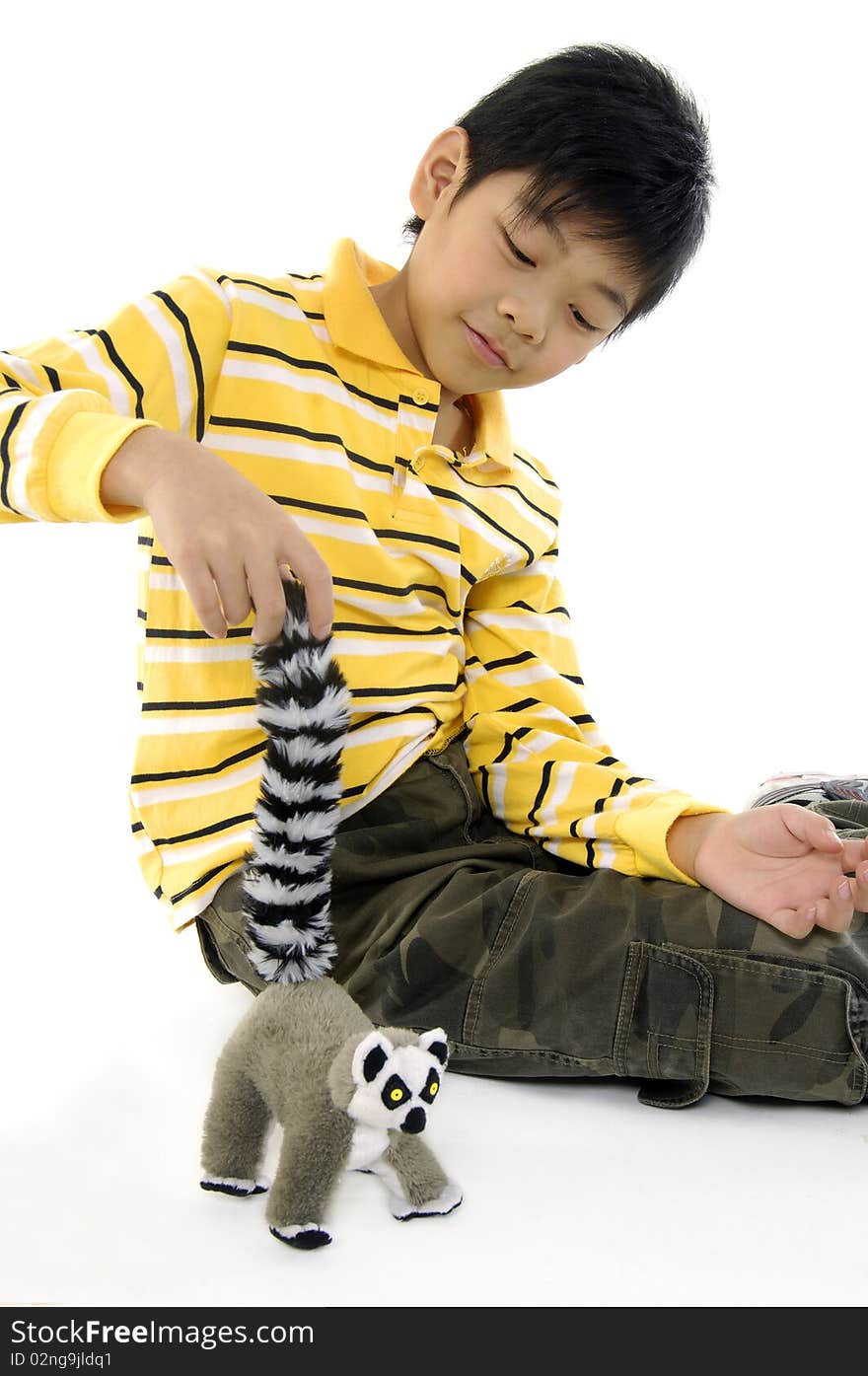 Photo of Asian kid with lemur toy. Photo of Asian kid with lemur toy