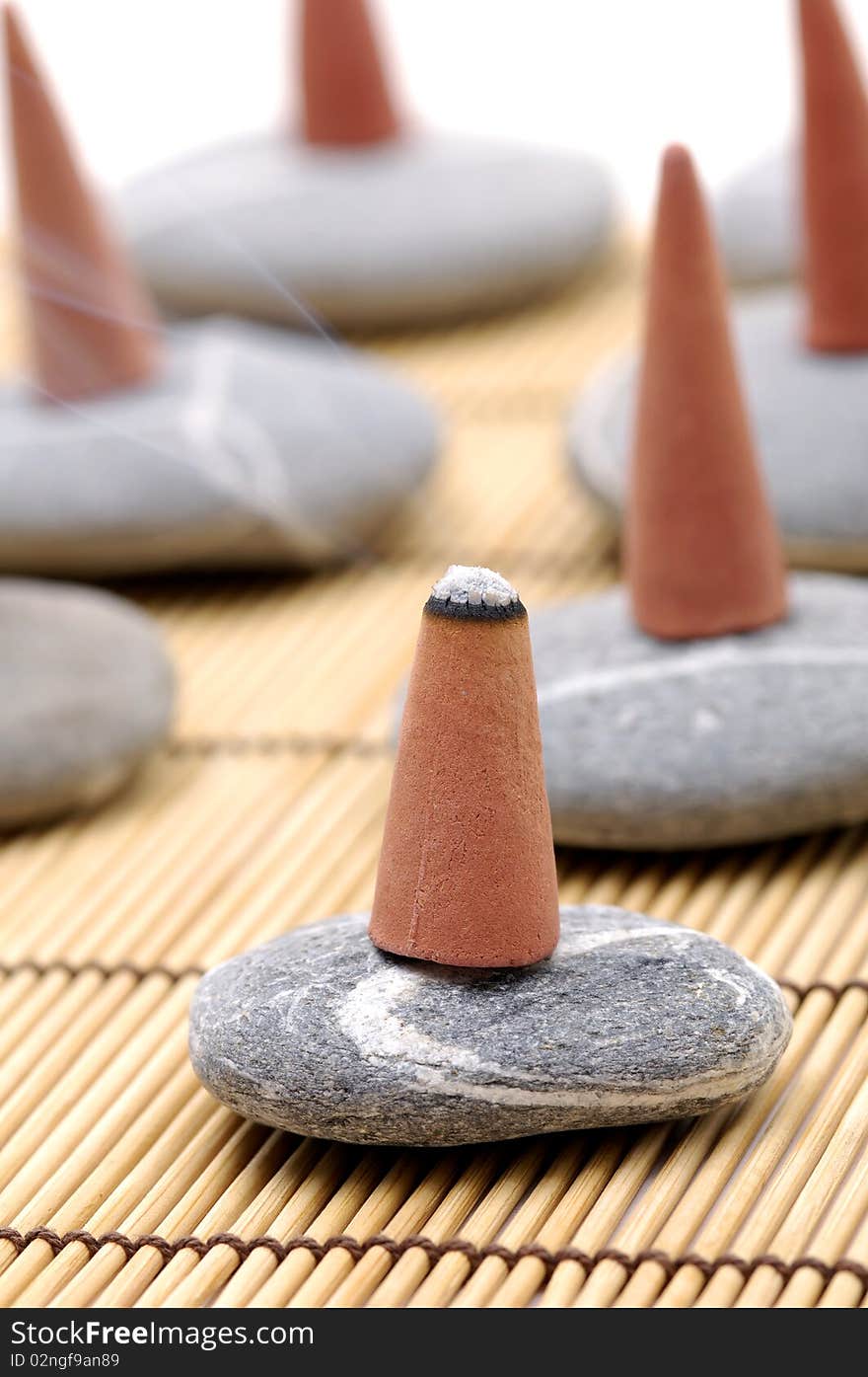 Incense cones and stone on bamboo mat. Incense cones and stone on bamboo mat