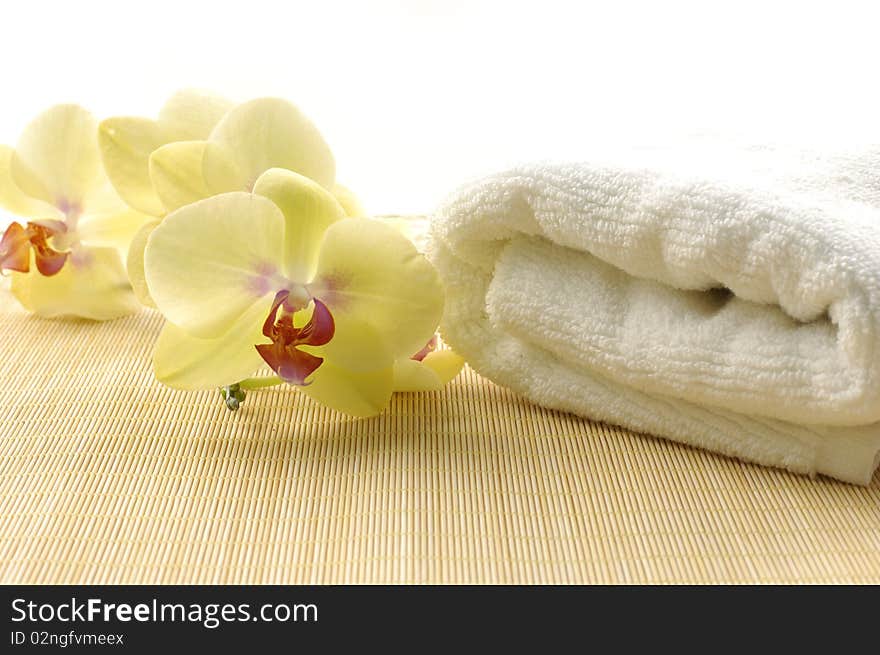 towel and orchids on bamboo mat. towel and orchids on bamboo mat