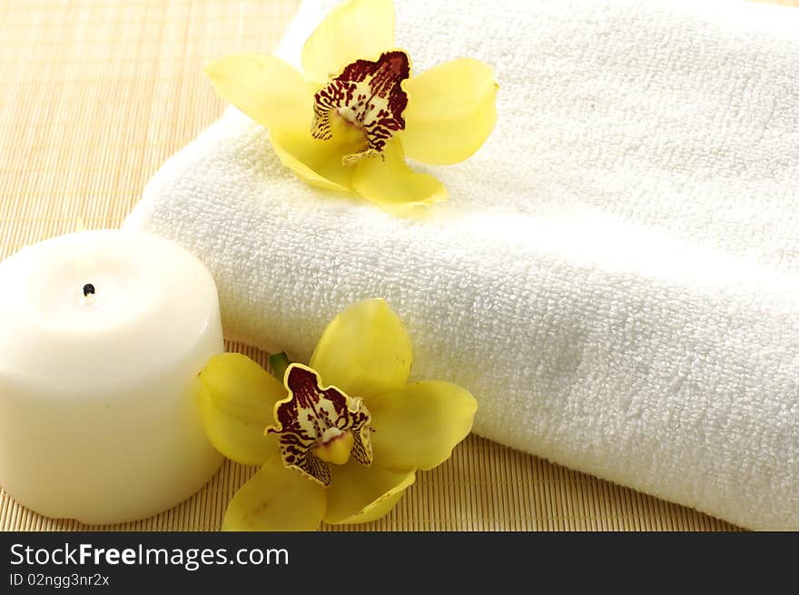 Candle, towel with yellower orchids. Candle, towel with yellower orchids