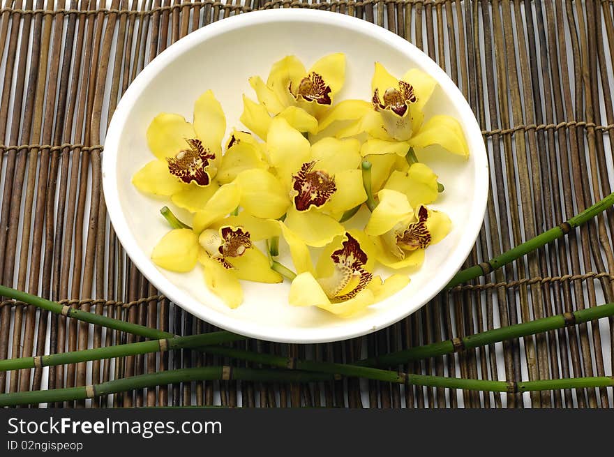 Bowl of orchid with thin on bamboo mat. Bowl of orchid with thin on bamboo mat