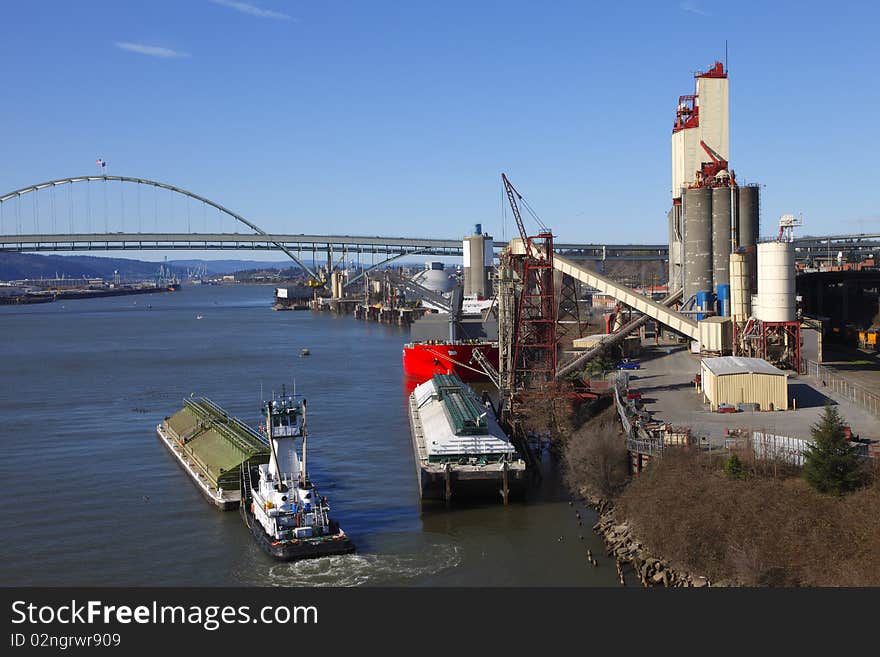 A push boat aligning the barge against the side of the dock to be moored for downloading cargo. A push boat aligning the barge against the side of the dock to be moored for downloading cargo.