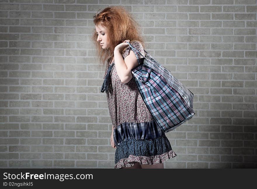 Tired redhaired woman with shopping bag.