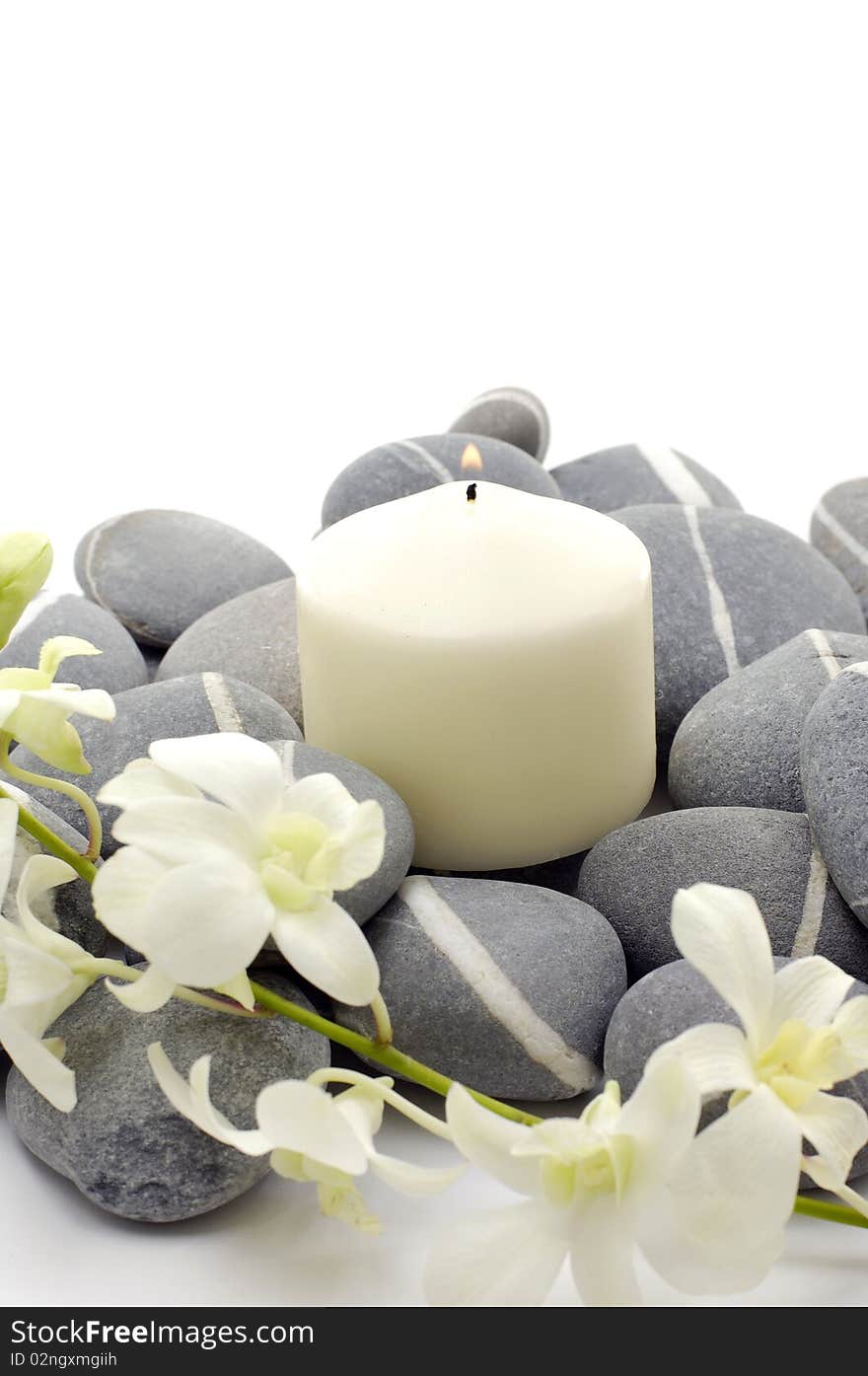 Spa setting- white flowers, pebbles and candle. Spa setting- white flowers, pebbles and candle