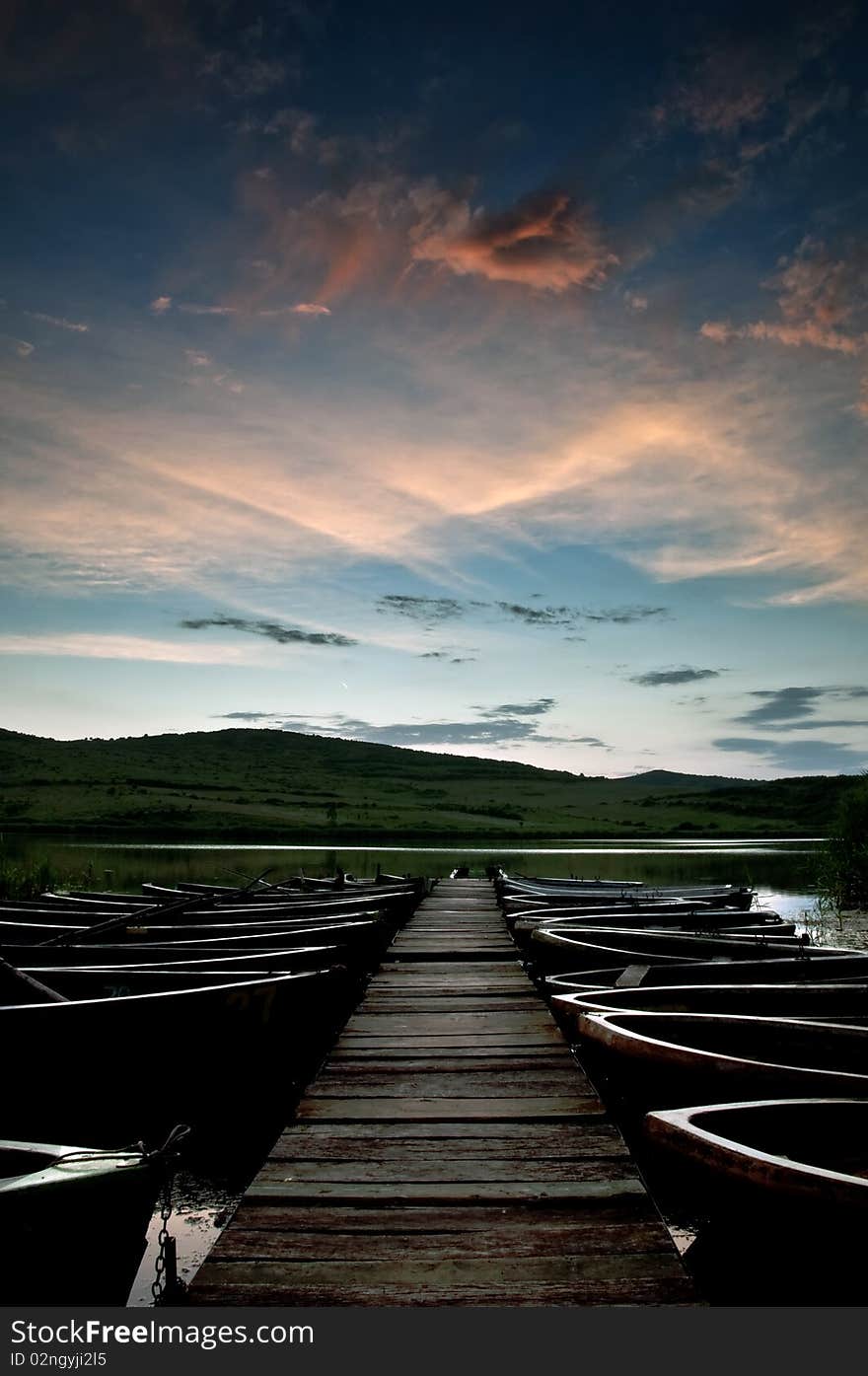 Boats on the lake besides a pontoon bridge with a beautiful sky. Boats on the lake besides a pontoon bridge with a beautiful sky