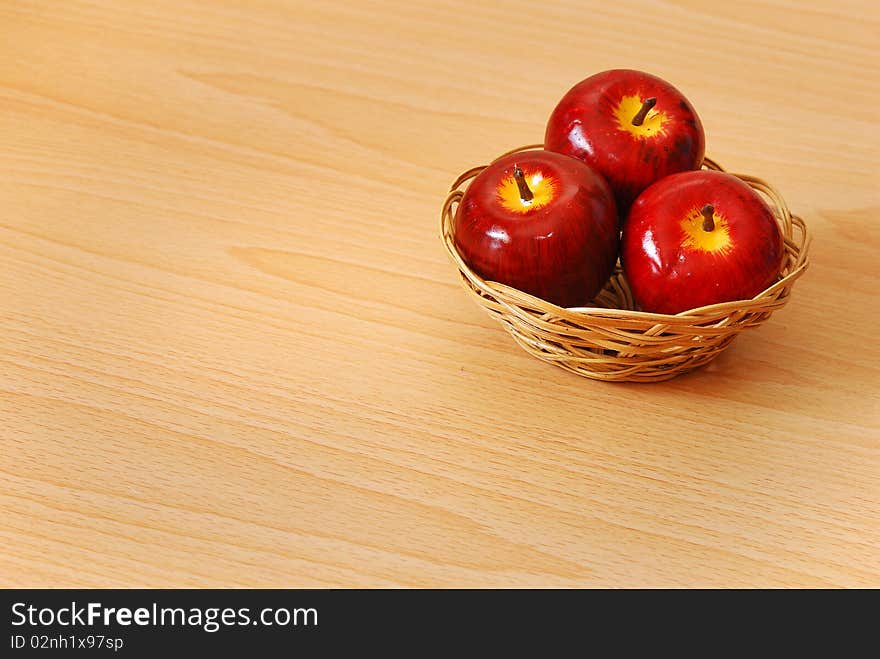 A basket with three red apples. A basket with three red apples