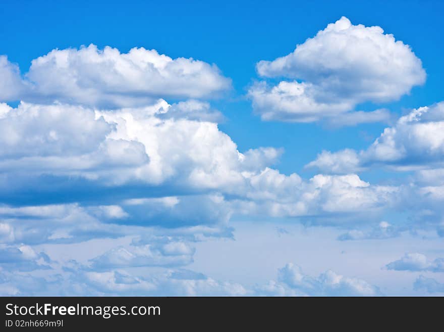 White cumulus clouds and a blue sky.