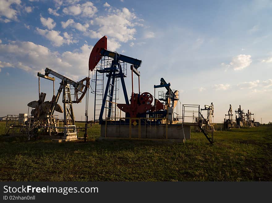 Oil pump worked in field at sunset. Oil pump worked in field at sunset