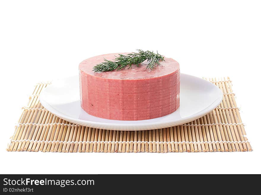 Sausage with fat impregnations is cut by slices and placed on a white plate. Sausage with fat impregnations is cut by slices and placed on a white plate.