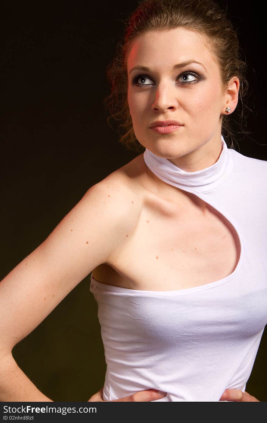 Young blonde fashion model in a studio setting striking a pose.