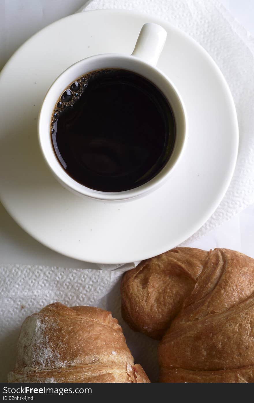 Cup of coffee with croissant