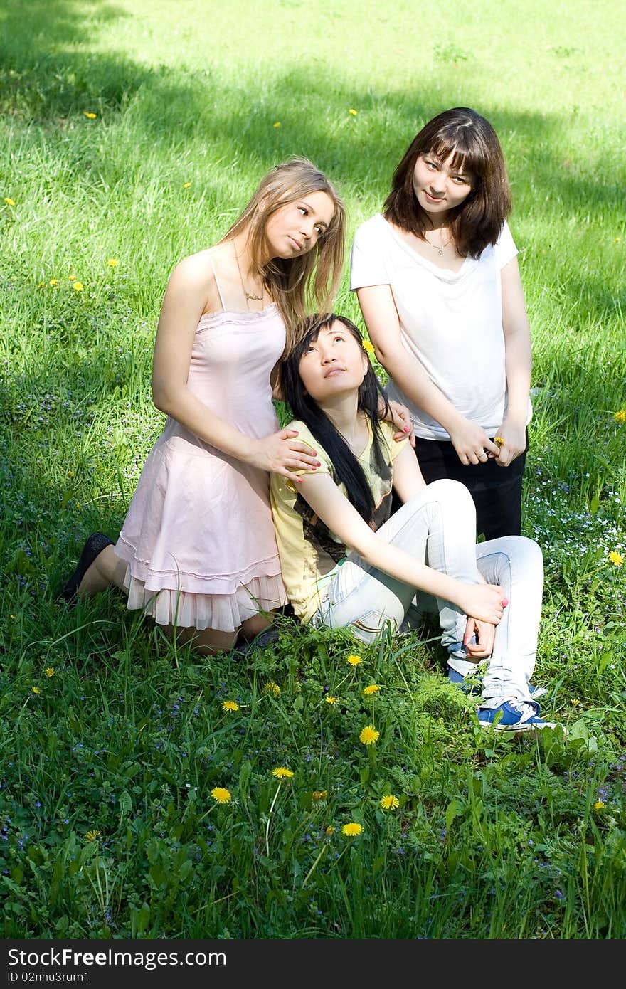 Three girls sitting on grass