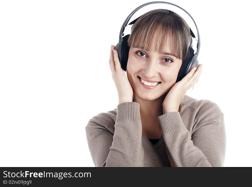 The young charming smiling girl listens to music in ear-phones