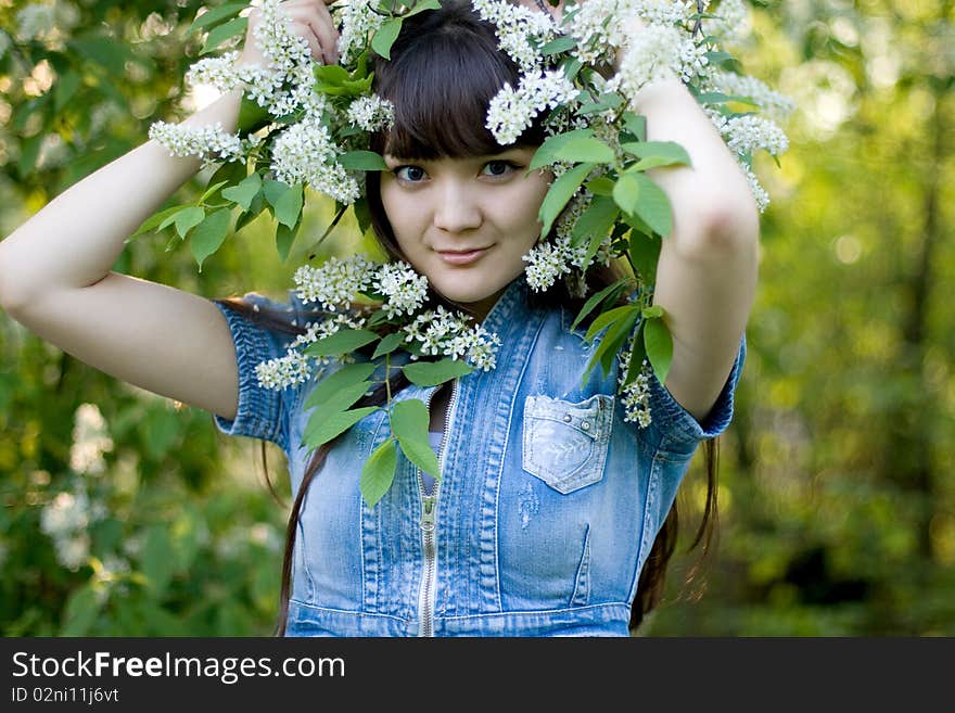 Girl standing near lilac in blossom