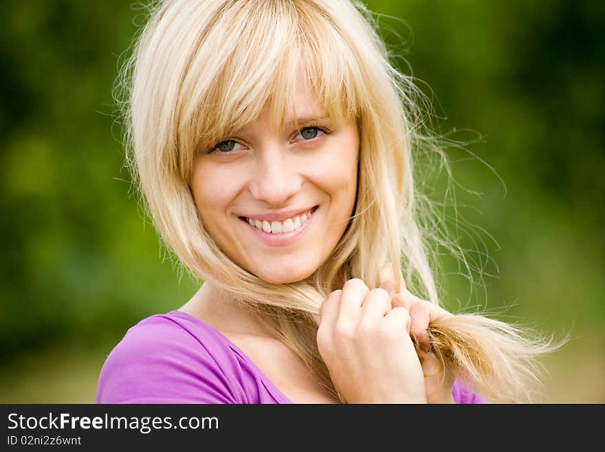 Portrait of young beautiful woman with fair hair on  background  of green forest. Portrait of young beautiful woman with fair hair on  background  of green forest