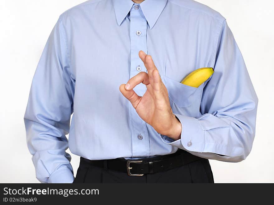 Man in the suit with the banana into pockets on the white background. Man in the suit with the banana into pockets on the white background