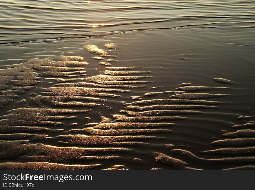 Sand ripples on beach with reflection of sunset. Sand ripples on beach with reflection of sunset