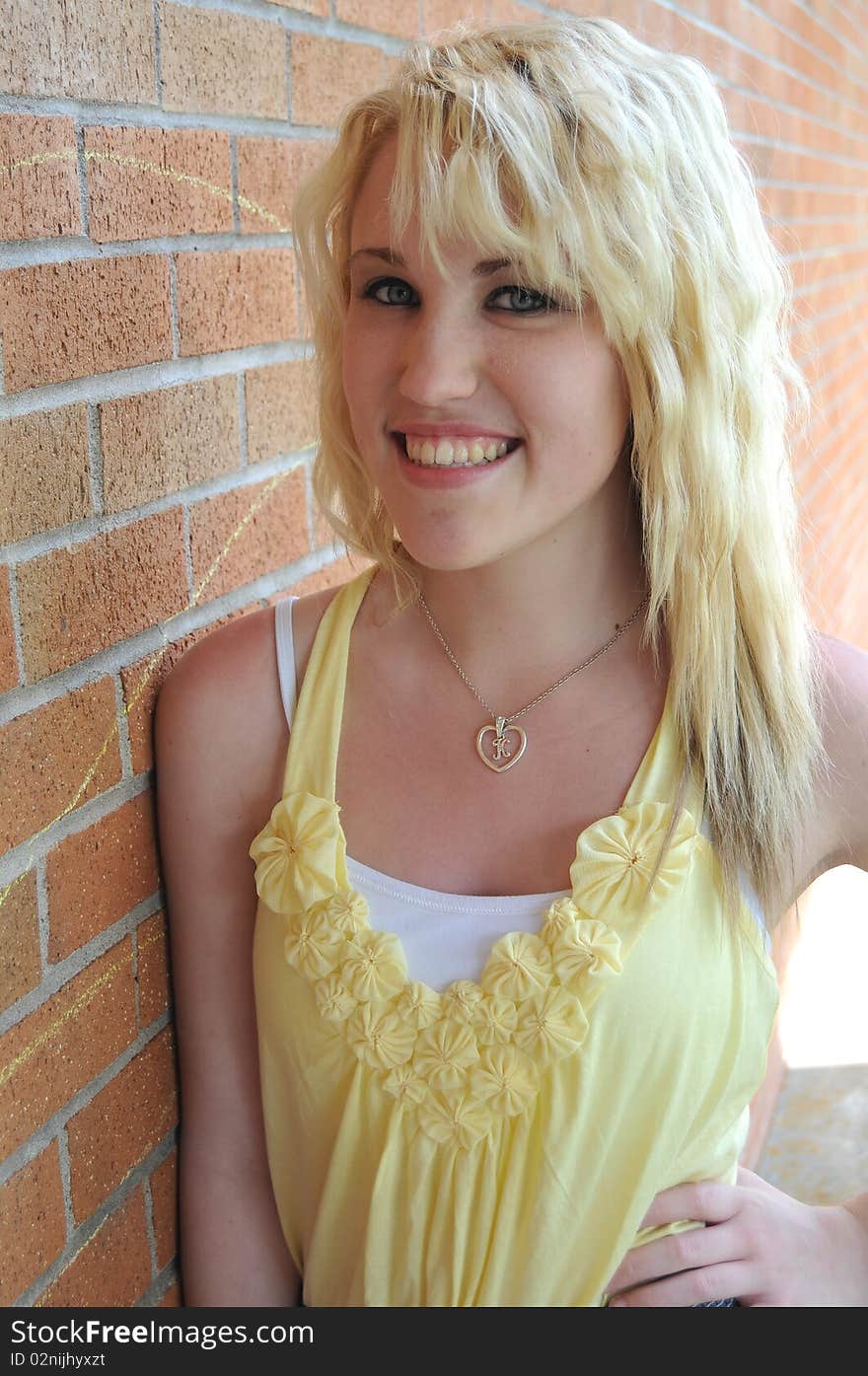 Girl standing next to brick wall