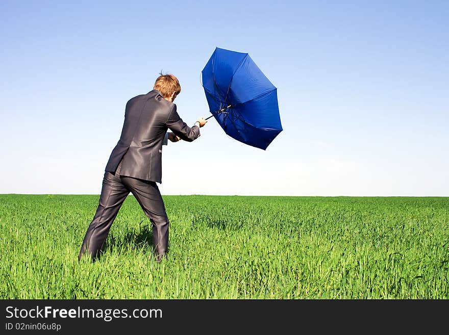 Businessman holding an umbrella in a storm.