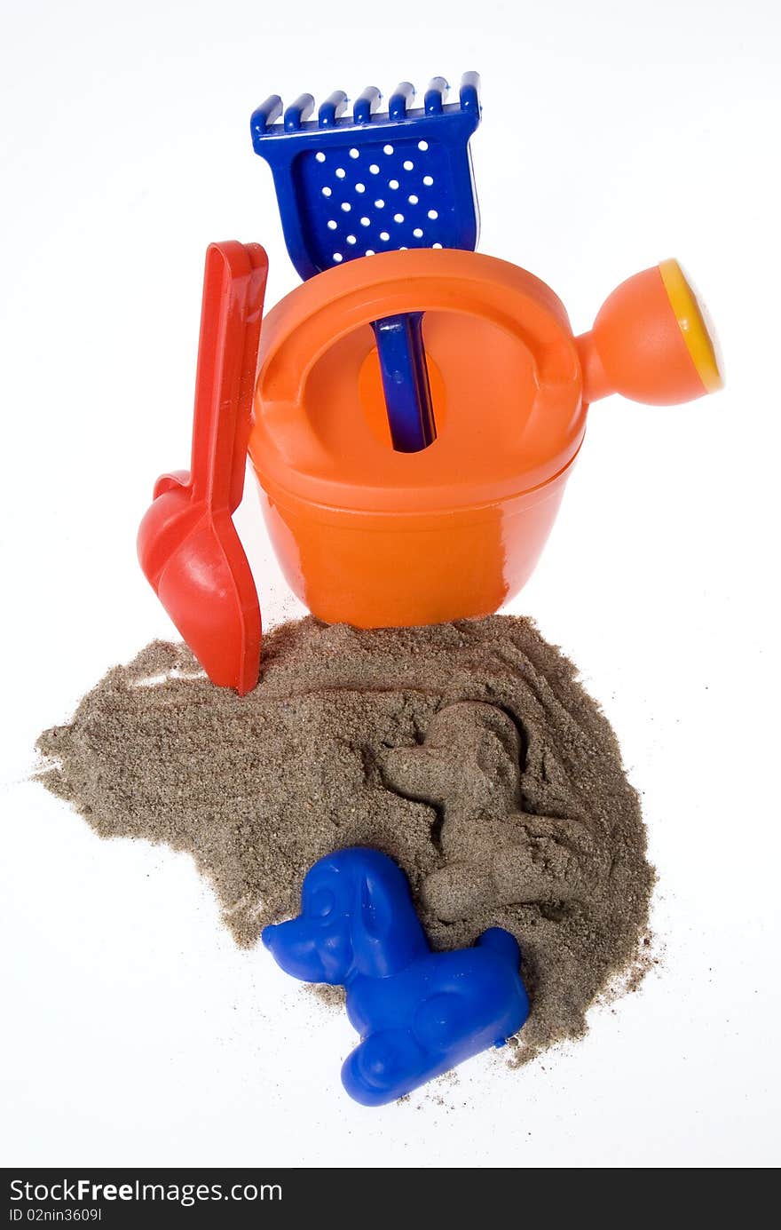 Sand play set - bucket, shovel, rack, mold and a pile of sand, on a white background. Sand play set - bucket, shovel, rack, mold and a pile of sand, on a white background