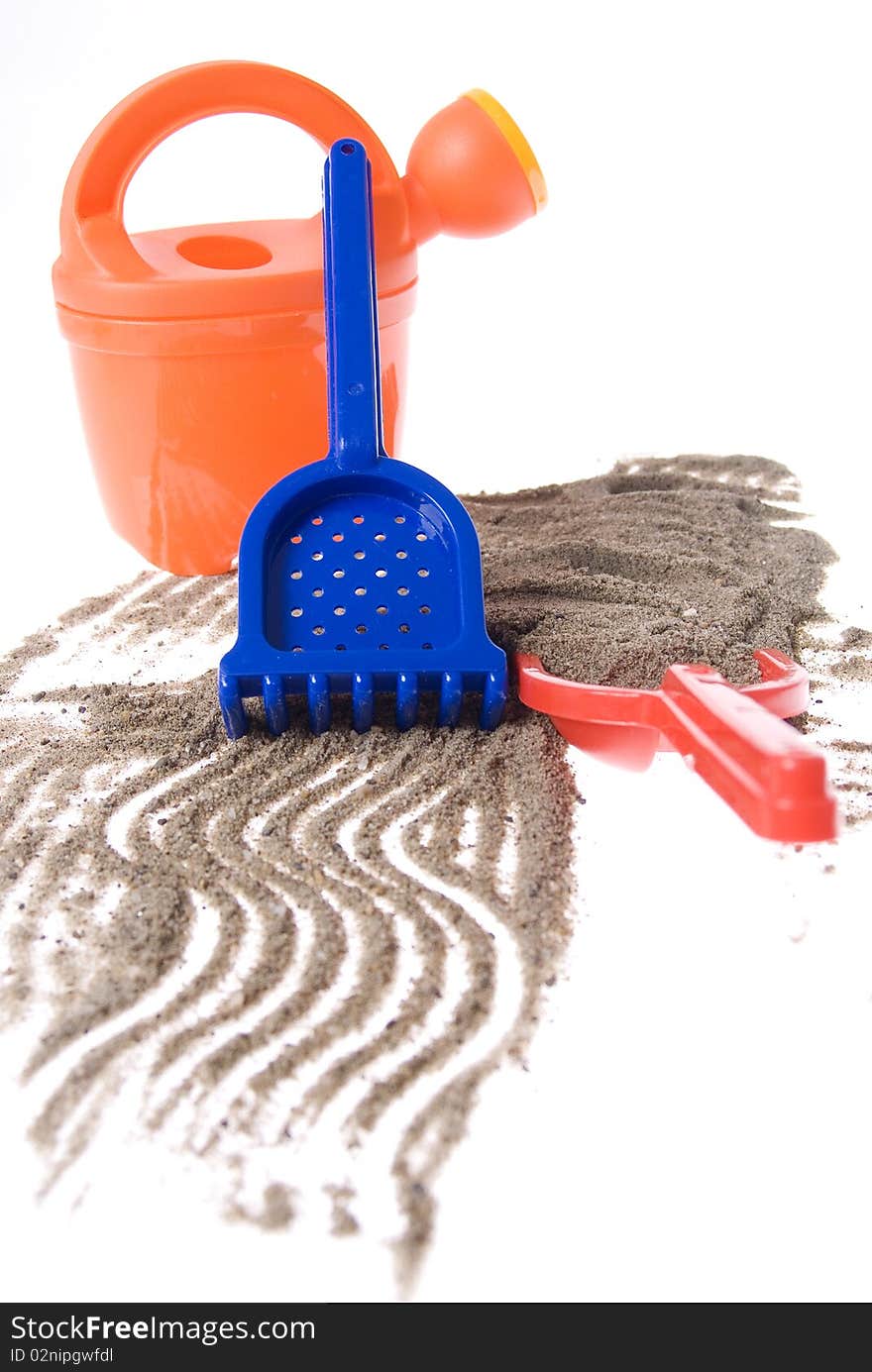 Sand play set - bucket, shovel, rack and a pile of sand, on a white background. Sand play set - bucket, shovel, rack and a pile of sand, on a white background