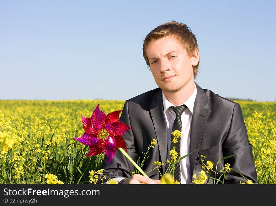 Businessman is resting in a field