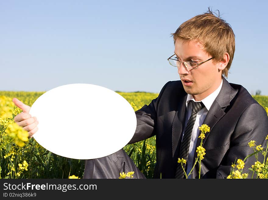 Surprised businessman in field looking at plate