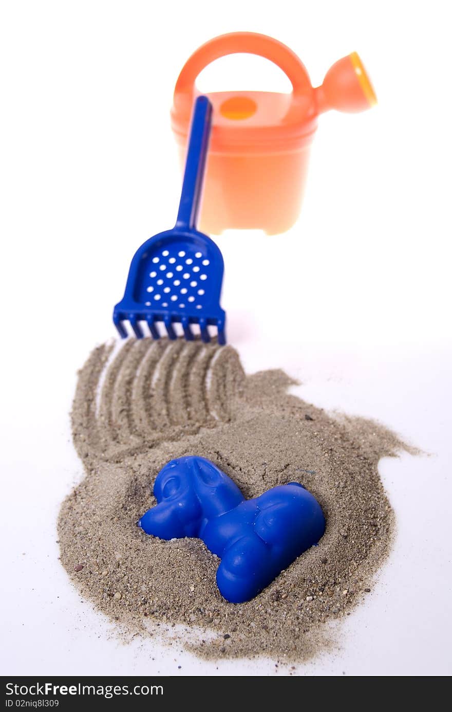 Sand play set - bucket, rack, mold and a pile of sand, on a white background. Sand play set - bucket, rack, mold and a pile of sand, on a white background