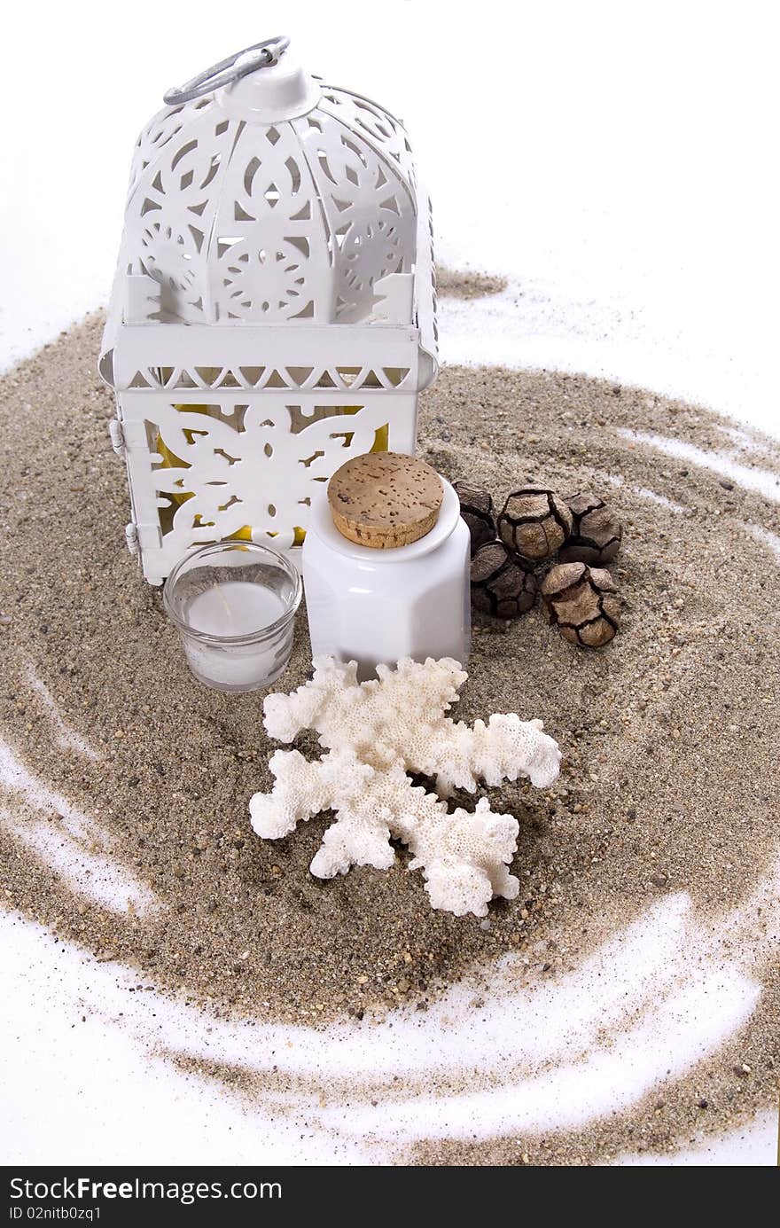 Sea coral, pine-cons, candles and small ceramic jar on a twirled pile of sand. Sea coral, pine-cons, candles and small ceramic jar on a twirled pile of sand.