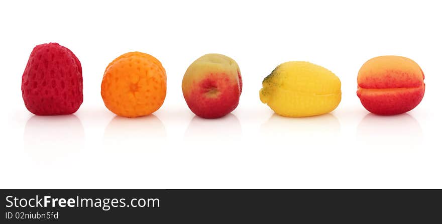 Marzipan fruit sweets, strawberry, orange, apple, lemon and plum, isolated over white background.