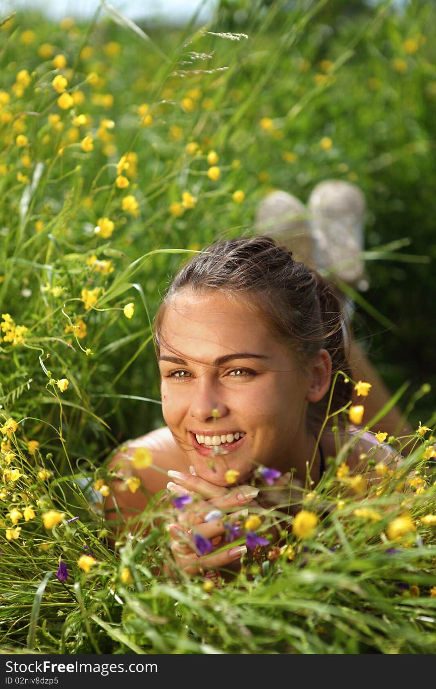 Beautiful girl lays on a meadow with flowers, summer. Beautiful girl lays on a meadow with flowers, summer