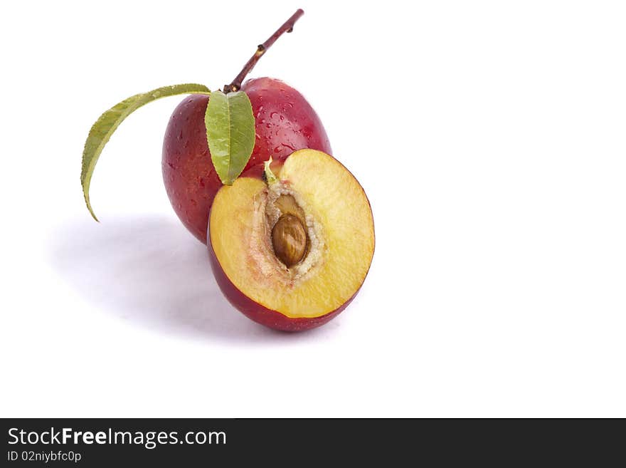 One nectarine with leafs and a slice. One nectarine with leafs and a slice