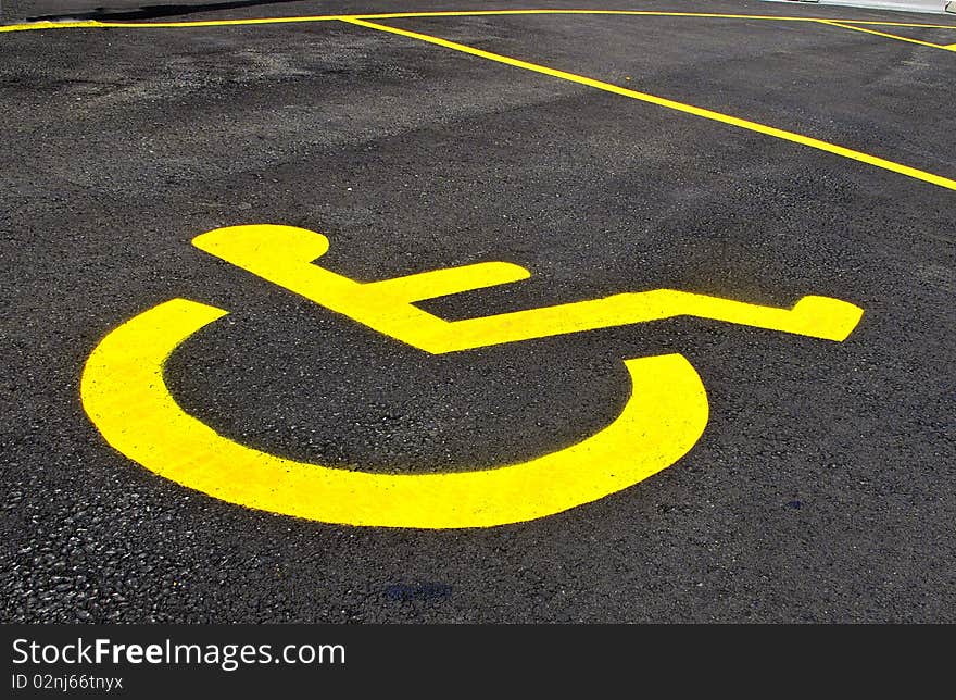 Yellow symbol for designated parking spot for handicapped driver. Yellow symbol for designated parking spot for handicapped driver