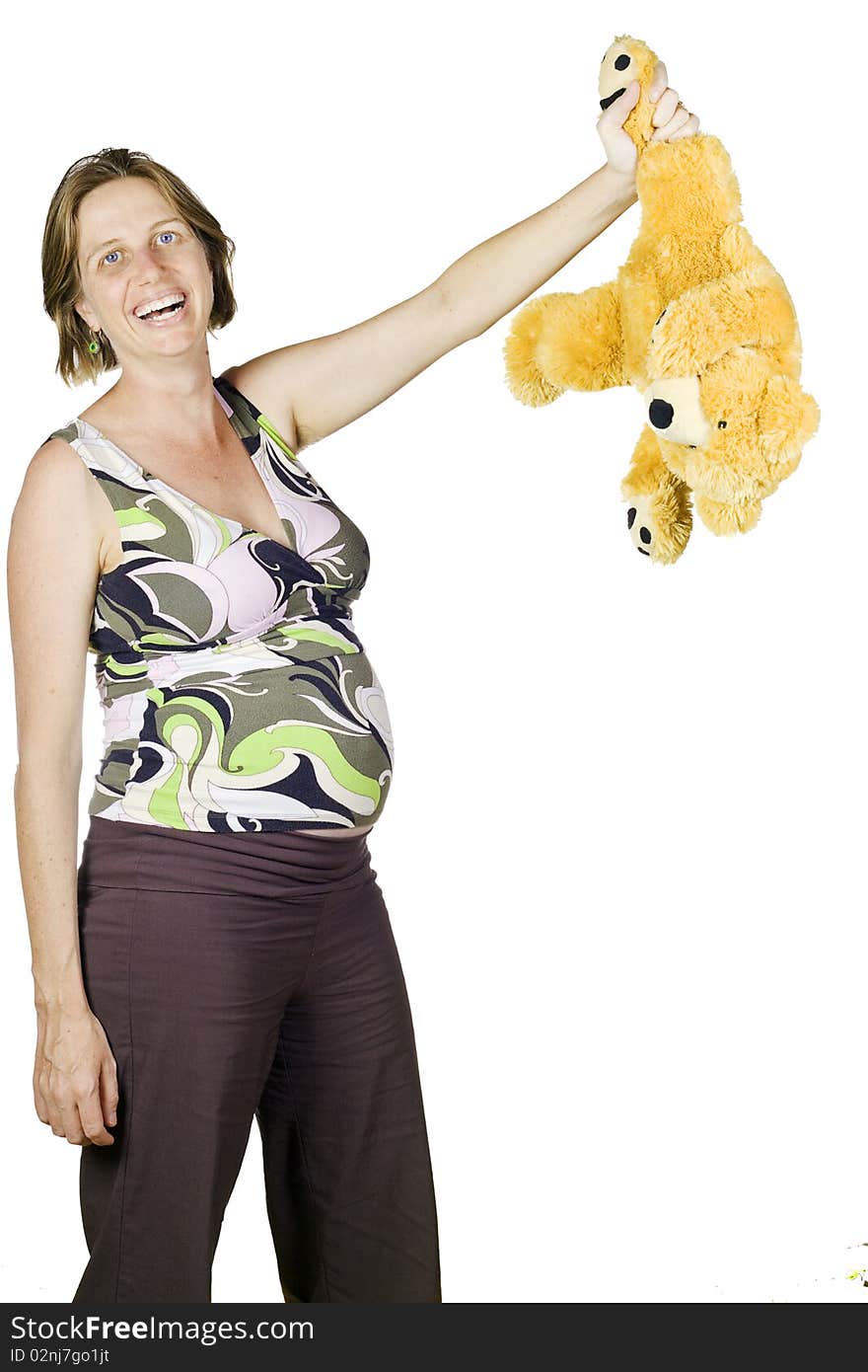 Funny portrait of pregnant woman laughing and holding a teddy by its leg.Isolated over white. Funny portrait of pregnant woman laughing and holding a teddy by its leg.Isolated over white.