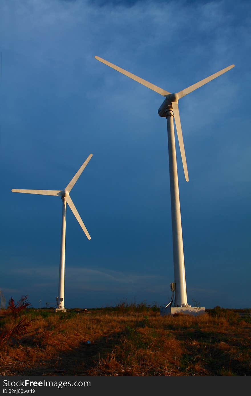 Modern wind turbines or wind mills in cloudy sky